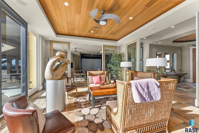 sunroom featuring a tray ceiling, ceiling fan, and wooden ceiling