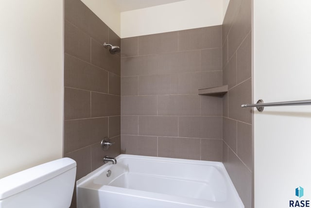 bathroom with toilet and tiled shower / bath