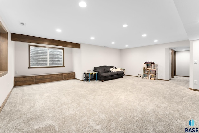 carpeted living room featuring beamed ceiling