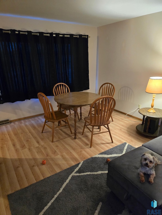 dining space featuring visible vents, baseboards, and wood finished floors