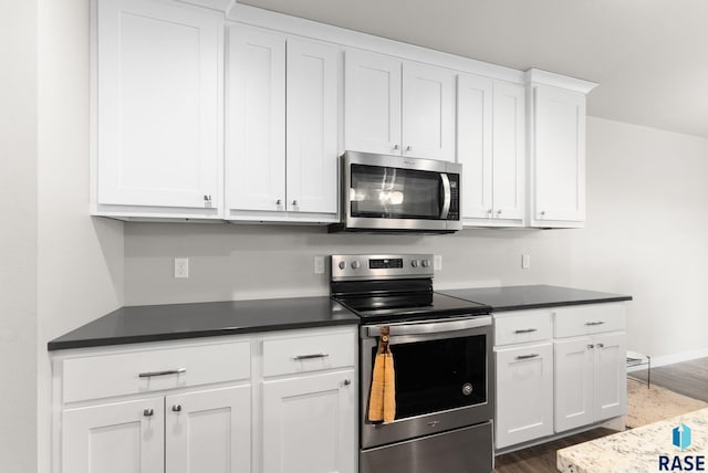 kitchen featuring appliances with stainless steel finishes, white cabinetry, and dark wood-type flooring