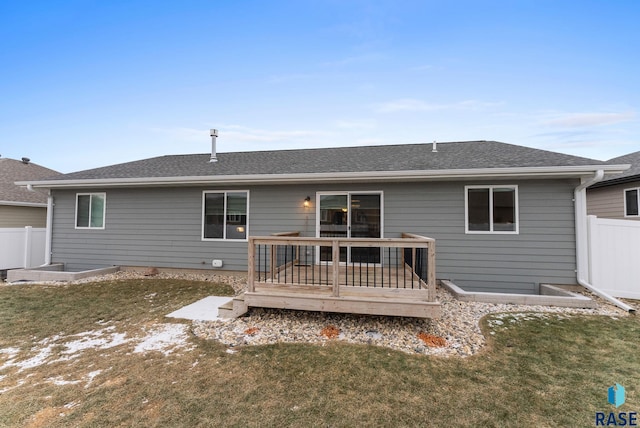 back of house with a wooden deck and a lawn