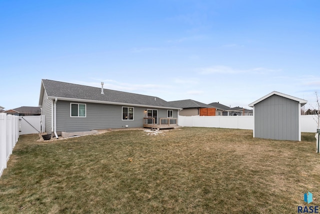 back of house with a yard, a wooden deck, and a storage unit