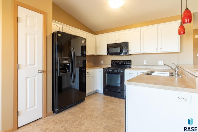 kitchen with pendant lighting, lofted ceiling, black appliances, sink, and white cabinetry