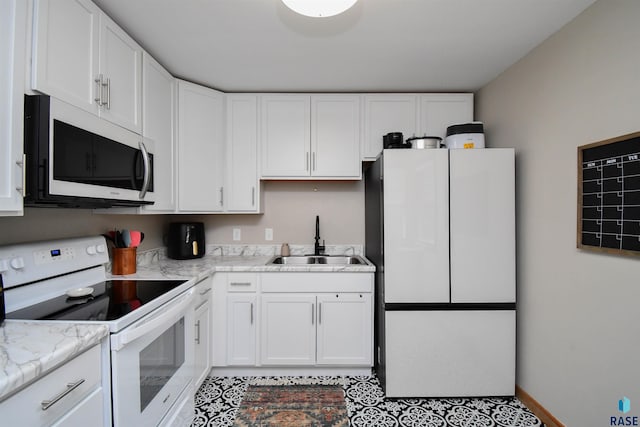 kitchen featuring light stone countertops, sink, white cabinets, and white appliances