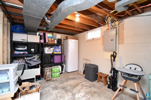 basement with white refrigerator and electric panel