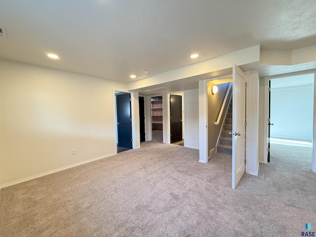 interior space featuring a walk in closet and light colored carpet