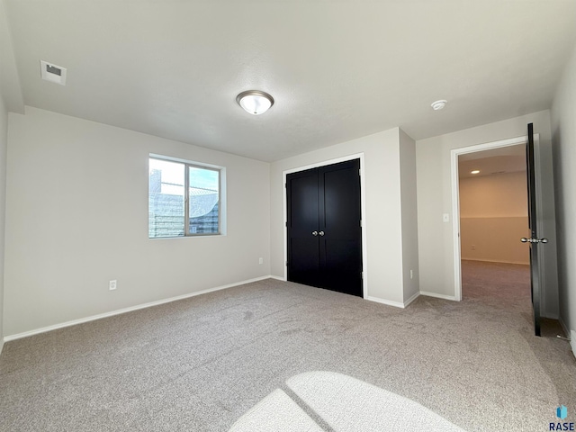 unfurnished bedroom featuring carpet flooring and a closet