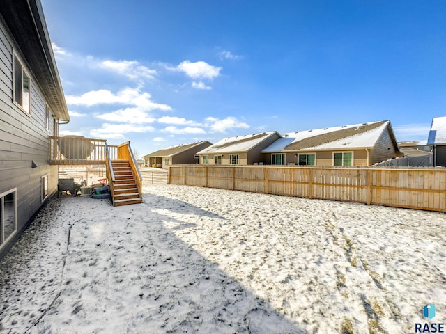 yard covered in snow with a wooden deck