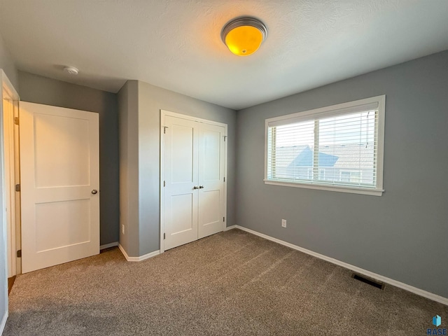 unfurnished bedroom with carpet floors and a closet