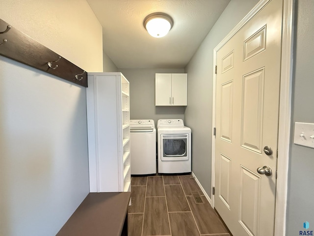 clothes washing area featuring cabinets and washing machine and clothes dryer