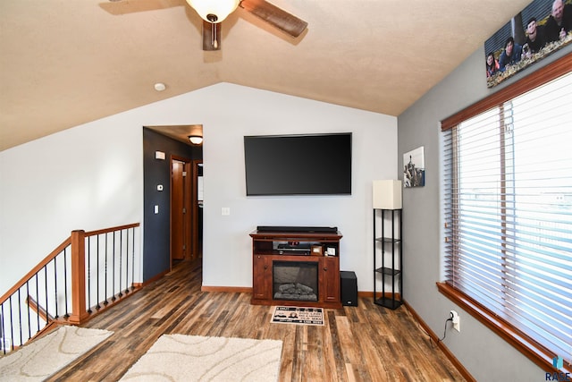 living room featuring ceiling fan, dark hardwood / wood-style flooring, and vaulted ceiling