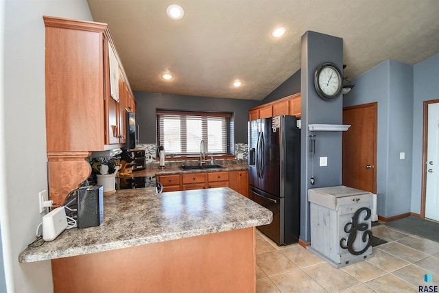 kitchen with kitchen peninsula, sink, vaulted ceiling, and black appliances