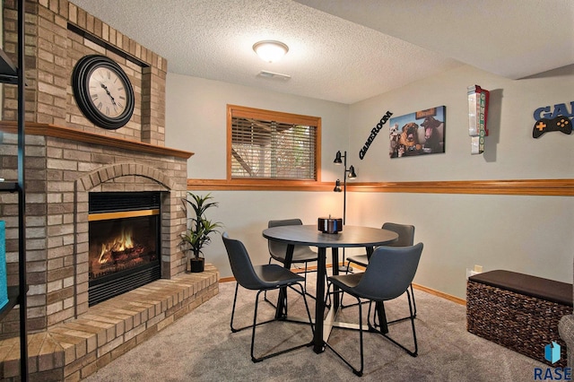 dining space with a fireplace, a textured ceiling, and carpet flooring