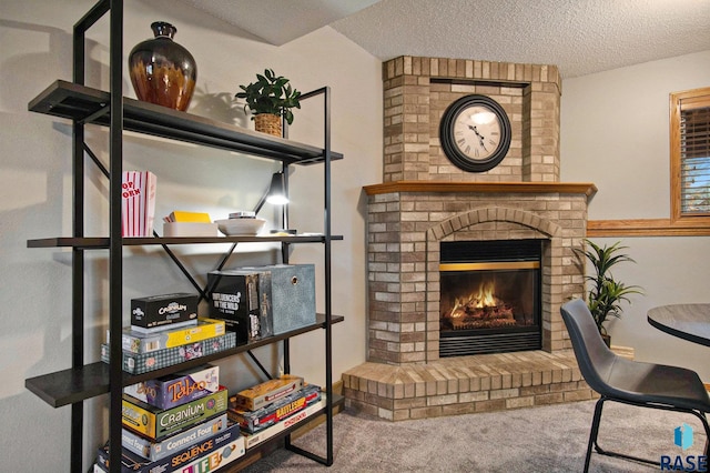 living area featuring a textured ceiling, carpet floors, and a brick fireplace