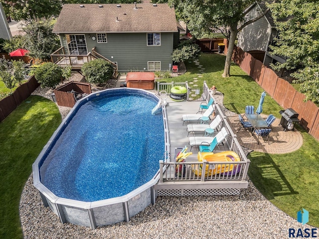 view of pool featuring a lawn and a deck