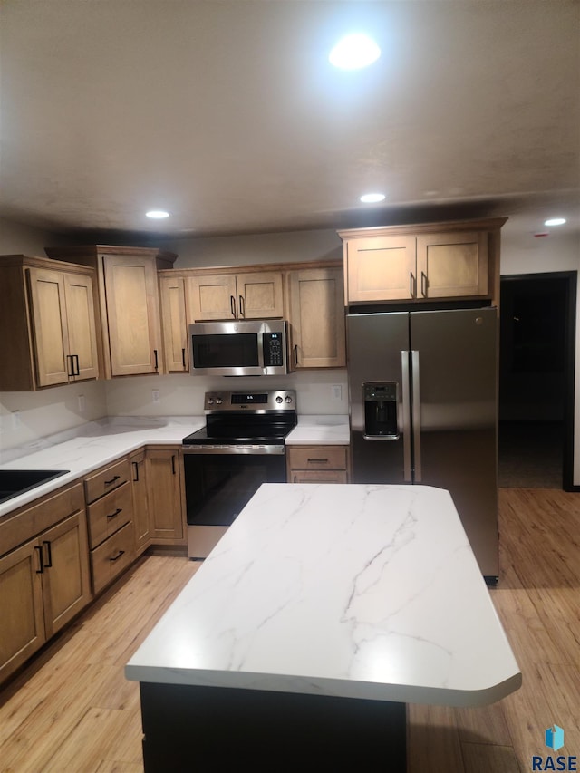 kitchen featuring a kitchen island, stainless steel appliances, and light hardwood / wood-style floors