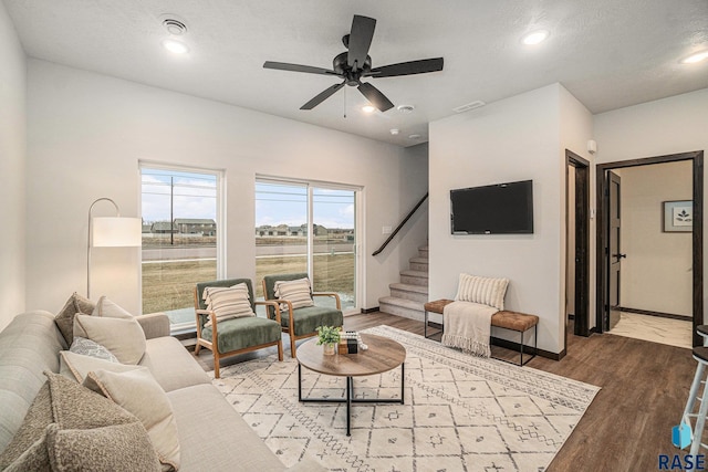 living room with ceiling fan, hardwood / wood-style floors, and a textured ceiling