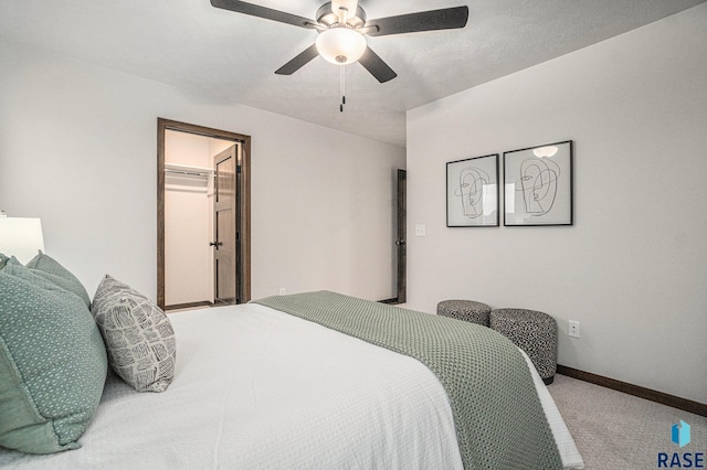 carpeted bedroom featuring a spacious closet, a closet, and ceiling fan