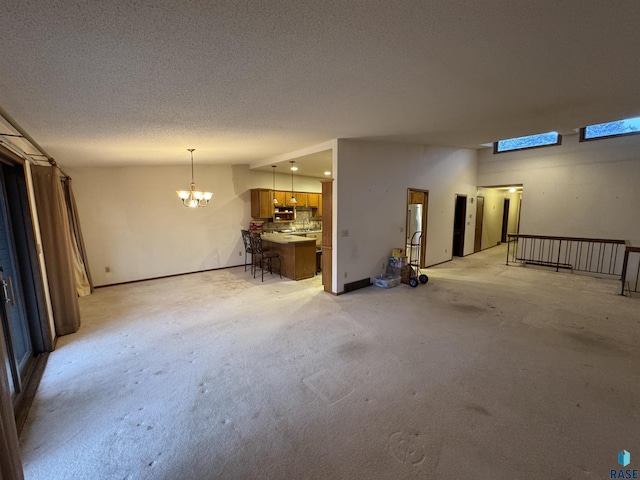 interior space featuring light colored carpet, a textured ceiling, and a notable chandelier