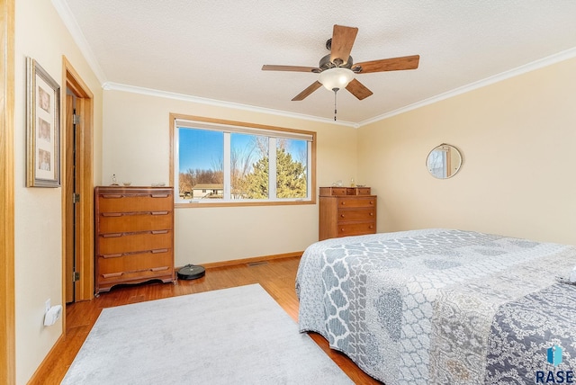 bedroom with ceiling fan, ornamental molding, a textured ceiling, and light wood-type flooring