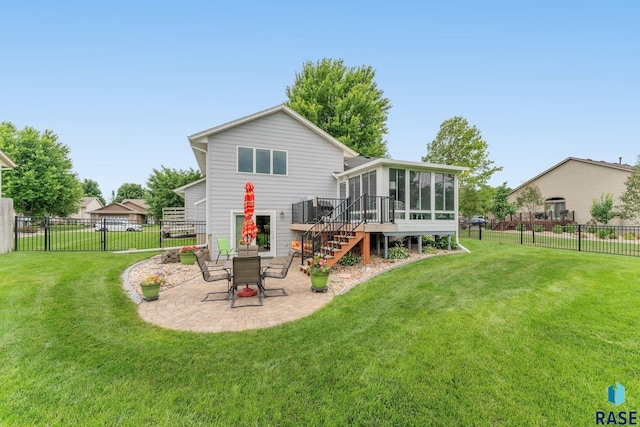 rear view of house featuring a lawn, a patio area, and a sunroom