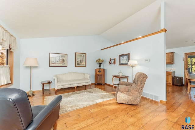 living area with light hardwood / wood-style flooring and lofted ceiling