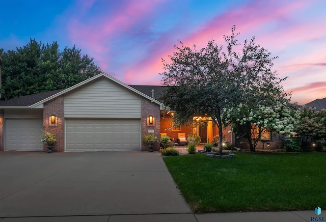 view of front of home with a lawn and a garage