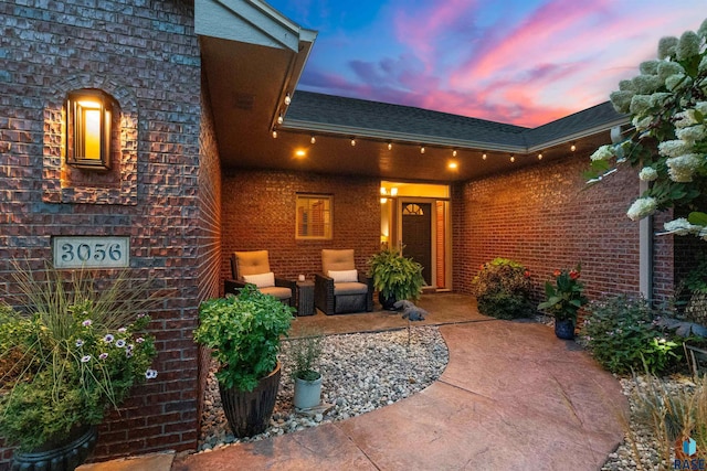 exterior entry at dusk featuring a patio