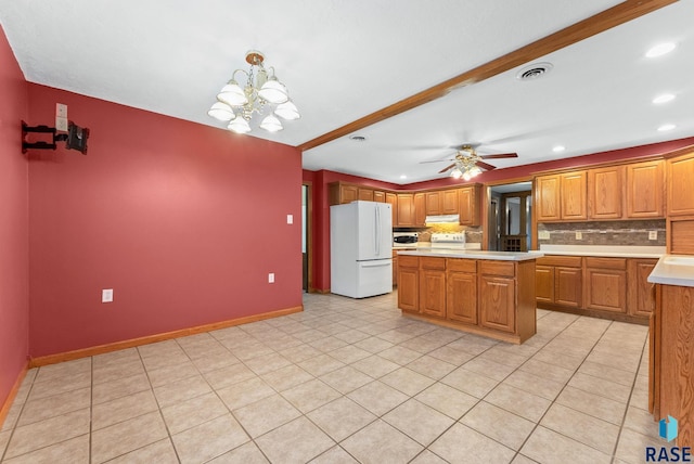 kitchen with a center island, decorative backsplash, white fridge, and decorative light fixtures