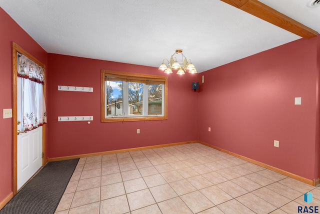 spare room featuring light tile patterned floors and a chandelier