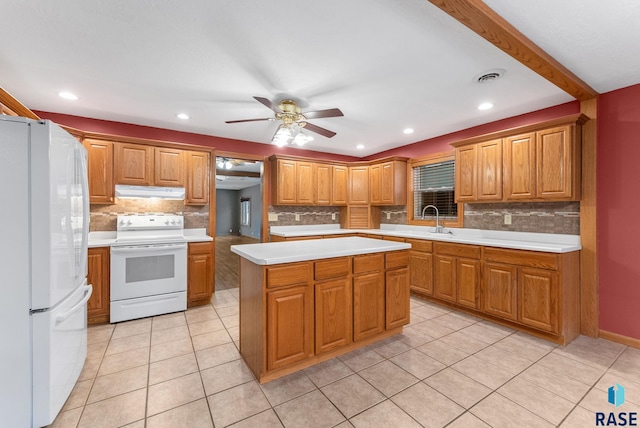 kitchen featuring a center island, white appliances, backsplash, sink, and ceiling fan