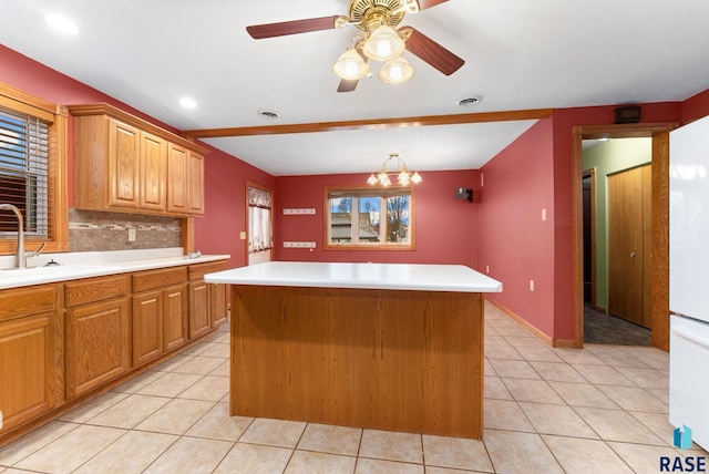 kitchen featuring tasteful backsplash, plenty of natural light, a kitchen island, and ceiling fan with notable chandelier