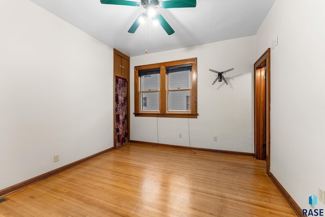 empty room with ceiling fan and light hardwood / wood-style flooring