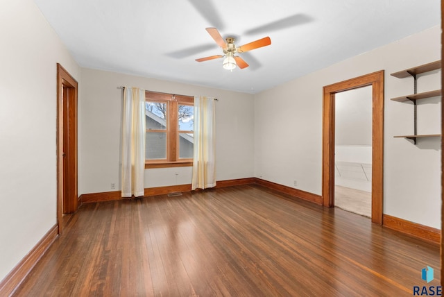 empty room featuring ceiling fan and dark wood-type flooring