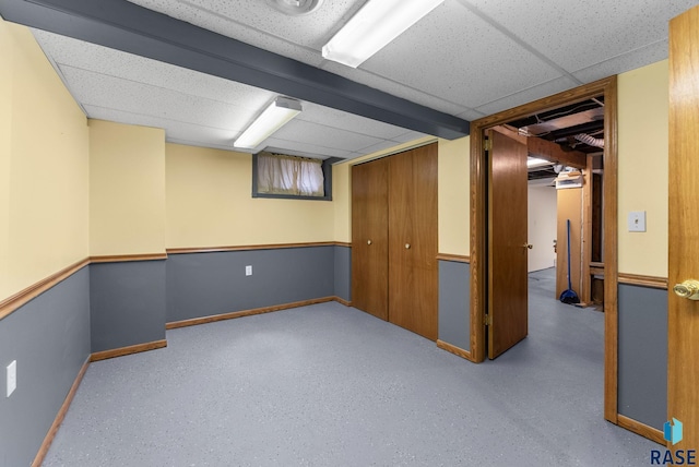 basement with a paneled ceiling