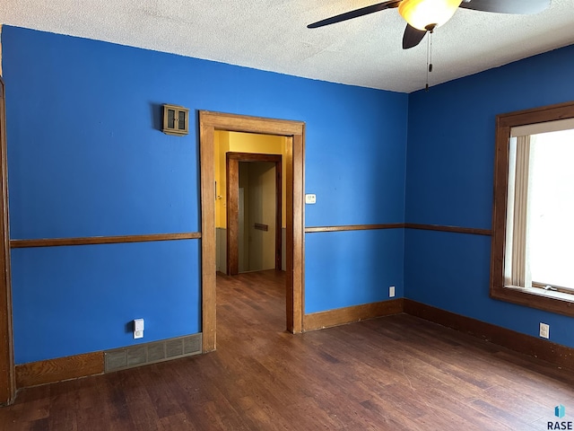 spare room featuring a textured ceiling, dark hardwood / wood-style flooring, and ceiling fan