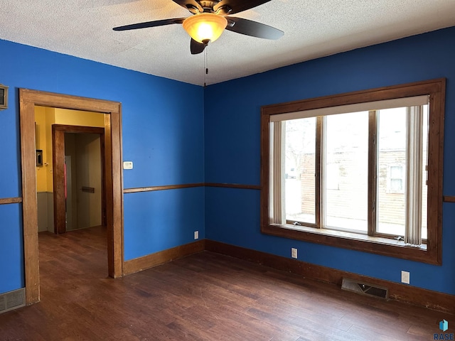 spare room featuring a textured ceiling, dark hardwood / wood-style flooring, and ceiling fan