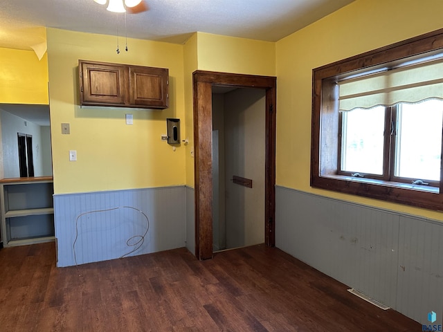 kitchen featuring dark hardwood / wood-style floors, ceiling fan, and wood walls