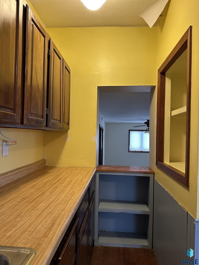 kitchen with ceiling fan, dark brown cabinets, and dark wood-type flooring