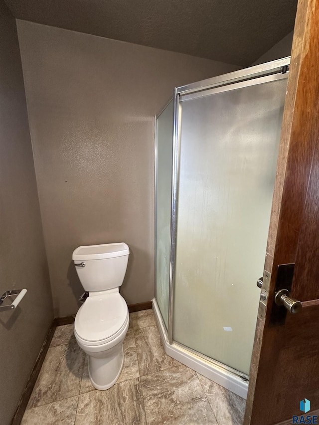 bathroom with toilet and a shower with shower door