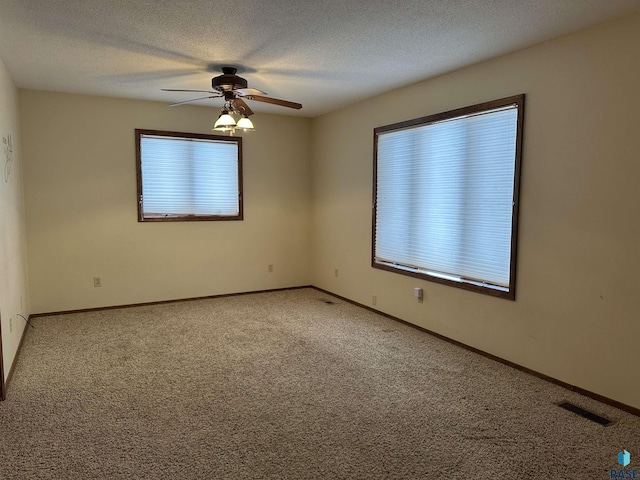 unfurnished room featuring carpet, ceiling fan, and a textured ceiling