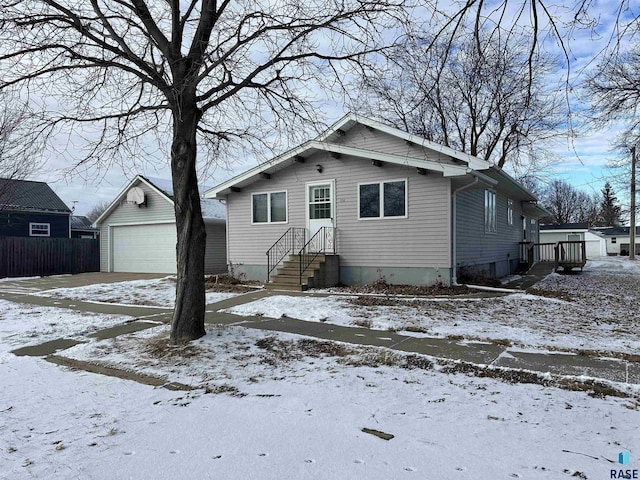 bungalow-style house featuring a garage and an outbuilding