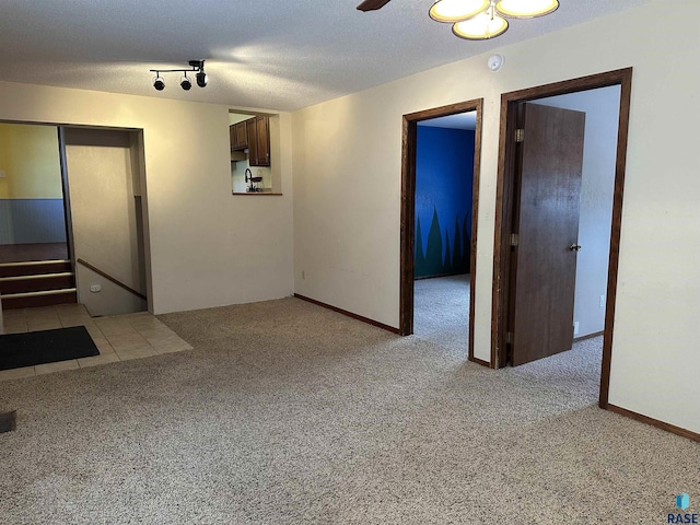 spare room with light carpet and a textured ceiling