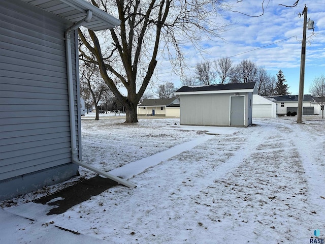 snowy yard featuring an outbuilding