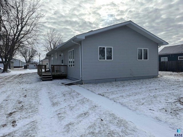 view of snow covered exterior with a deck