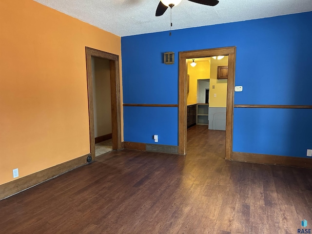 unfurnished room with ceiling fan, dark hardwood / wood-style flooring, and a textured ceiling