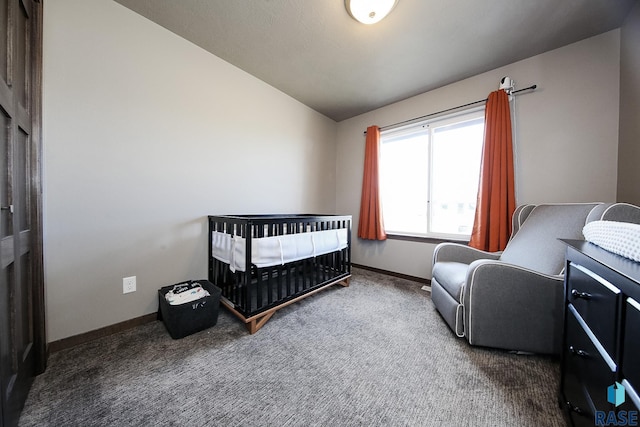 carpeted bedroom featuring vaulted ceiling and a nursery area