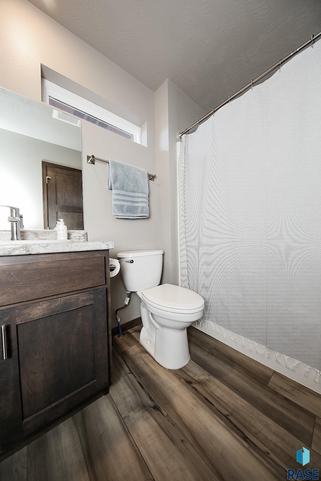 bathroom featuring vanity, toilet, and hardwood / wood-style floors