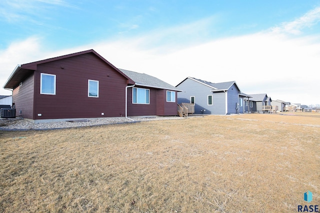 back of property with a yard and central AC unit